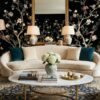 Daisy Bennett mural wallpaper by RUBY featuring delicate floral trees with blossoms and birds on a black background, styled in a modern luxury living room with a white sofa and soft decor