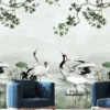Luxury neutral grey mural wallpaper featuring elegant cranes, lotus flowers, and botanical branches in a serene landscape design, styled in a modern living room with beige sofa and green armchairs by RUBY Furnishing Studio Ghatkopar East Mumbai.