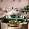 Elegant pink mural wallpaper featuring artistic cranes, lotus elements, and delicate tree branches with green leaves, styled with modern blue lounge chairs in a luxury interior by RUBY Furnishing Studio Ghatkopar East Mumbai.