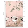 Elegant pink mural wallpaper featuring artistic cranes, lotus elements, and delicate tree branches with green leaves, styled with modern blue lounge chairs in a luxury interior by RUBY Furnishing Studio Ghatkopar East Mumbai.