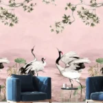 Elegant pink mural wallpaper featuring artistic cranes, lotus elements, and delicate tree branches with green leaves, styled with modern blue lounge chairs in a luxury interior by RUBY Furnishing Studio Ghatkopar East Mumbai.