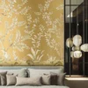 Elegant golden yellow floral mural wallpaper with delicate tree branches, blooming flowers, and birds in a luxury living room with blush seating and ornate mirror