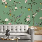 Green floral bird mural wallpaper with delicate white blossoms and perched birds, luxury botanical wall design in an elegant modern classic living room with teal sofa.