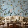 Elegant floral bird mural wallpaper with pastel blue background, featuring blooming branches, lemons, and colorful birds in a classic vintage style living room setting.