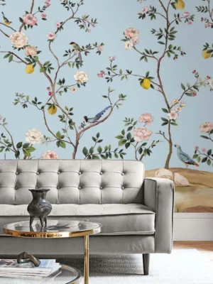 Elegant floral bird mural wallpaper with pastel blue background, featuring blooming branches, lemons, and colorful birds in a classic vintage style living room setting.