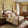 Warm yellow floral bird mural wallpaper with delicate blossoms, citrus accents, and birds, elegant botanical wall design in a luxury bedroom setting with soft pink seating.