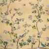 Warm yellow floral bird mural wallpaper with delicate blossoms, citrus accents, and birds, elegant botanical wall design in a luxury bedroom setting with soft pink seating.