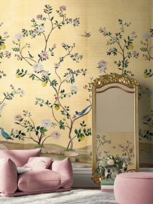 Warm yellow floral bird mural wallpaper with delicate blossoms, citrus accents, and birds, elegant botanical wall design in a luxury bedroom setting with soft pink seating.