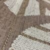 Casamance FILANDRA 7698 25 48 geometric textured wallpaper in warm beige and brown tones installed on a modern living room feature wall with premium designer interior décor.