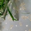 Premium sage green non-woven wallpaper with elegant gold botanical vines and delicate white floral pattern, perfect for living rooms, bedrooms, feature walls, nurseries, and luxury home interiors.