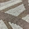 Casamance FILANDRA 7698 25 48 geometric textured wallpaper in warm beige and brown tones installed on a modern living room feature wall with premium designer interior décor.
